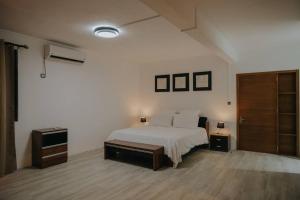 a bedroom with a white bed and two night stands at Amazing Sunset view rooftop. in Flic-en-Flac