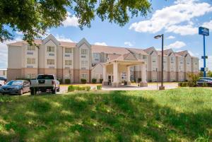 a large building with cars parked in a parking lot at Microtel Inn and Suites Lafayette in Lafayette