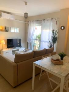 sala de estar con sofá y mesa en Bonito Apartamento en la Macarena en Sevilla