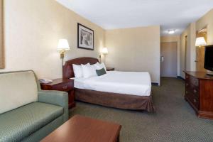 a hotel room with a bed and a couch at Ramada by Wyndham Reno Hotel & Casino in Reno