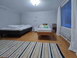 a room with two beds and a table in it at Mäki-mummola in Ylitornio