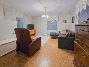 sala de estar con sofá y silla en Mäki-mummola, en Ylitornio