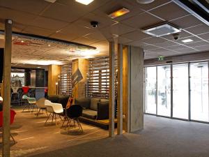 a meeting room with chairs and a couch and tables at ibis Paris Porte D'Orleans in Montrouge