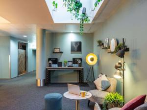 a lobby with a couch and a table with a laptop at Novotel Edinburgh Centre in Edinburgh