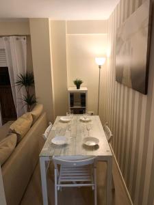 una mesa blanca y sillas en una habitación con sofá en Bonito Apartamento en la Macarena en Sevilla