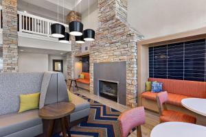 a lobby with a fireplace and a couch and chairs at Hampton Inn & Suites Petoskey in Petoskey