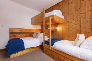 Ce lit se trouve dans un dortoir doté de 2 lits superposés et de murs en bois. dans l'établissement Sunny Nest - View Of MB Montroc - Happy Rentals, à Chamonix-Mont-Blanc