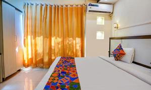 a bedroom with a large bed with a colorful blanket at FabExpress Prabhu Sharan in Mumbai