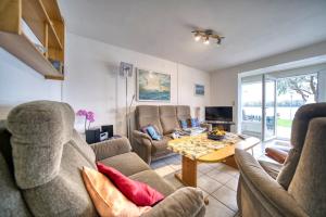 ein Wohnzimmer mit Sofas und einem Tisch in der Unterkunft Haus am See, App 3HAS06 in Heiligenhafen