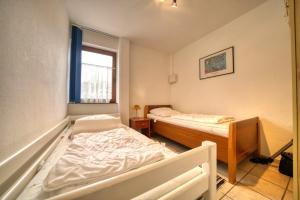 1 Schlafzimmer mit 2 Betten und einem Fenster in der Unterkunft Haus am See, App 3HAS06 in Heiligenhafen