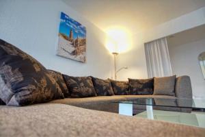 uma sala de estar com um sofá e uma mesa de vidro em Ferienpark - Haus Q, App 0QEG03 em Heiligenhafen