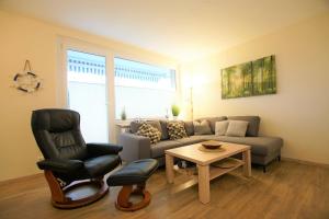 sala de estar con sofá y silla en Ferienpark - Haus Q, App 0QEG07, en Heiligenhafen