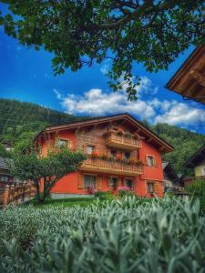 an orange building with a balcony on it at Casa Clus Bormio apartments 2 in Valdisotto