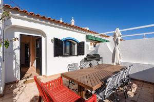 a patio with a wooden table and chairs at Vila Ramalhete W/ 3 BDR & Balcony by LovelyStay in Altura