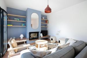 a living room with a gray couch and a blue wall at Vila Ramalhete W/ 3 BDR & Balcony by LovelyStay in Altura