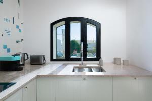 a kitchen with a sink and a window at Vila Ramalhete W/ 3 BDR & Balcony by LovelyStay in Altura +19 photos