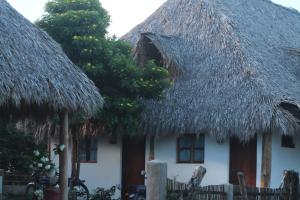 ein Haus mit einem Strohdach und zwei Fenstern in der Unterkunft Wild Waves Surf-House in Popoyo