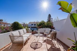 a patio with a couch and chairs on a balcony at Vila Ramalhete W/ 3 BDR & Balcony by LovelyStay in Altura