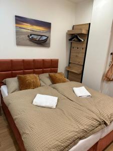 a bedroom with a large bed with two towels on it at Sunny House One in Bratislava