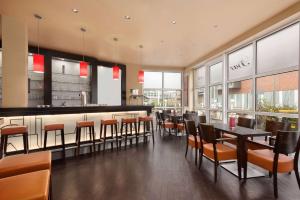 a restaurant with a bar with chairs and tables at Ramada by Wyndham Bottrop City in Bottrop