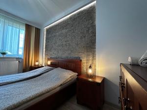 ein Schlafzimmer mit einem Bett und einer Ziegelwand in der Unterkunft M&M Apartament Glogera in Krakau