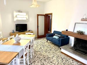 ein Wohnzimmer mit einem Tisch und einem Kamin in der Unterkunft Casa Vacanza Sergio e Carla in Gioiella