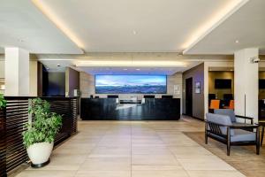 an office lobby with a large screen in the background at La Quinta by Wyndham Santiago Aeropuerto in Santiago