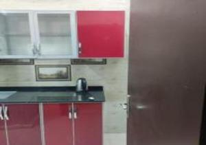 uma cozinha com armários vermelhos e um frigorífico vermelho em نجمة حراء للشقق المفروشة em Jidá