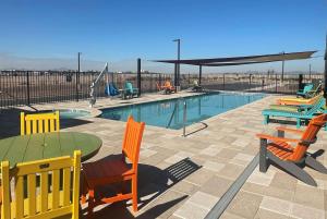 una piscina con sillas, una mesa y una mesa con sillas en La Quinta Inn & Suites by Wyndham Yuma, en Yuma