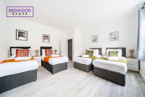 três camas num quarto com paredes brancas em BRAND NEW, 2 Bed 1 Bath, Modern Town Center Apartment, FREE WiFi & Netflix By REDWOOD STAYS em Aldershot
