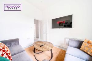 uma sala de estar com um sofá e uma mesa em BRAND NEW, 2 Bed 1 Bath, Modern Town Center Apartment, FREE WiFi & Netflix By REDWOOD STAYS em Aldershot