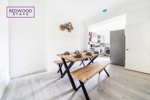 uma sala de jantar com uma mesa com tigelas em BRAND NEW, 2 Bed 1 Bath, Modern Town Center Apartment, FREE WiFi & Netflix By REDWOOD STAYS em Aldershot