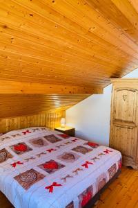 - une chambre avec un grand lit et un plafond en bois dans l'établissement Gîte Le Cosy Dream des Xettes, à Gérardmer