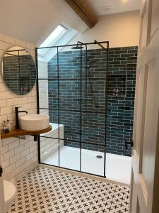 a bathroom with a glass shower and a sink at Tynycornel Hotel in Tal-y-llyn