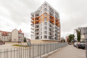 a tall apartment building with a fence in front of it at Międzyzdroje Horyzont - Apartament z Klimatyzacją i Balkonem by Renters in Międzyzdroje