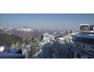 a view of a snow covered mountain with a building at Chandel Home Stay , Shimla in Shimla