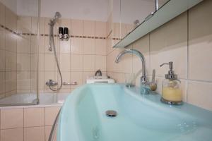 ein Badezimmer mit einer Badewanne und einem Waschbecken in der Unterkunft Apartment with a private terrace located right near Belvedere Castle, 15 minutes away from Stephansdom in Wien