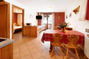 eine Küche und ein Esszimmer mit einem Tisch und Stühlen in der Unterkunft Chalet Primula 7 in Santa Caterina Valfurva