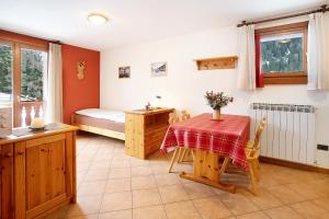 Zimmer mit einem Tisch und einem Bett sowie einem Schlafzimmer in der Unterkunft Chalet Primula 7 in Santa Caterina Valfurva