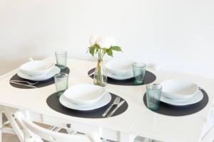 a white table with plates and glasses on it at Central 5 - 10 min Paris - 30 min Disney - Free Parking - 5 min RER A in Fontenay-sous-Bois