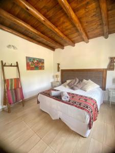 a bedroom with a large bed and wooden ceilings at La Nochera in Tilcara