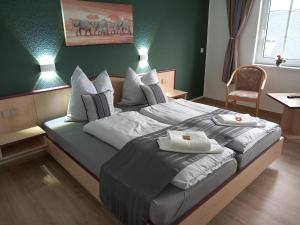 a bedroom with a bed with two towels on it at Hotel Eintracht in Mittweida
