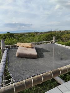 a hammock with a pillow on top of a field at biohotel tatacoa Qji in Villavieja