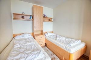 twee bedden in een kleine kamer met ermottermottermott bij Haus Hanseatic, App 2SC304 in Heiligenhafen