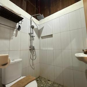 a bathroom with a shower and a toilet and a sink at BATA MERAH GUESTHOUSE BATU in Punten +27 photos