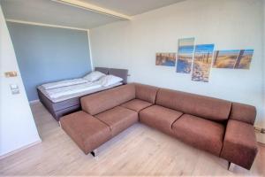 een woonkamer met een bank en een bed bij Haus Hanseatic, App 2SC104 in Heiligenhafen