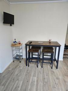 une table à manger avec deux chaises et une télévision dans l'établissement Studio La Marmotte Appart 327, à La Féclaz