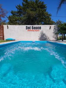 a pool of blue water in front of ald solvo sign at Cabañas Apart del Sauce II in Paraná