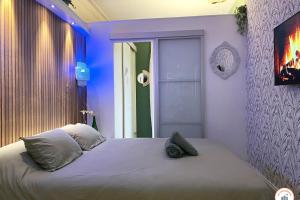 - une chambre dotée d'un grand lit avec des lumières bleues dans l'établissement Bienvenue au Chillou - Parking - Terrasse, au Havre
