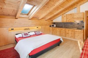 una camera con un grande letto e una cucina di Chalet Primula 14 a Santa Caterina Valfurva